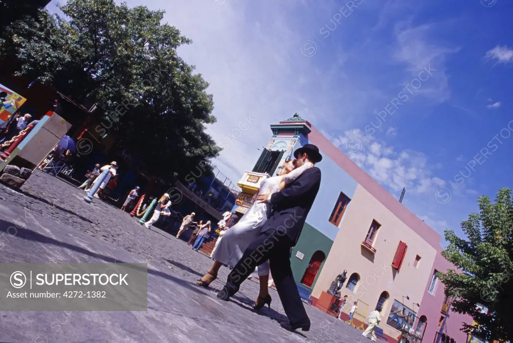 Argentina, Buenos Aires. Tango dancers in the colourful and popular area known as La Boca in Buenos Aires. La Boca is located by the port. The area is popular among tourists for its artists, painters fair, open air tango shows, and typical Italian cantinas.