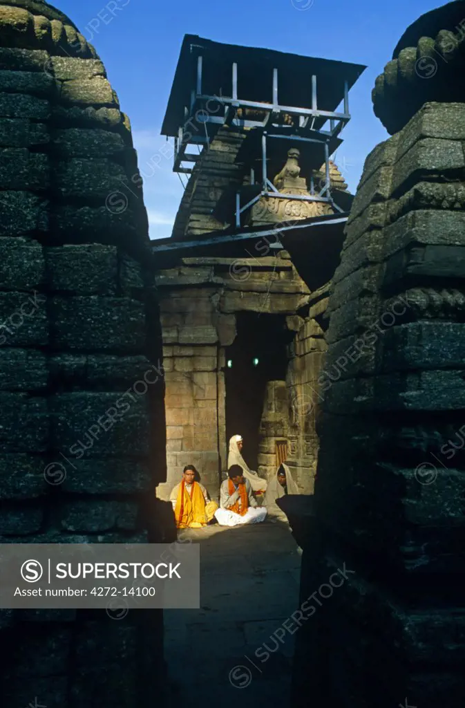 India, Uttarakhand, Kumaon, Jageshwar. Temple priests sit outside one of this ancient site's many sacred temples.