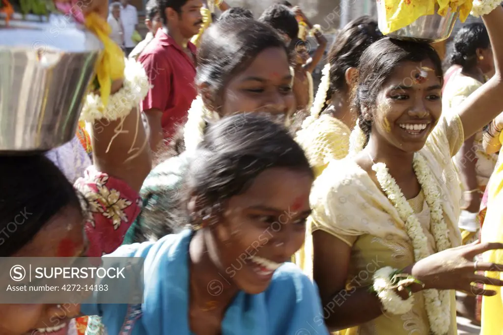 India, Tamil Nadu. Women carrying offerings to the Tamil God of War, Murugan, accompany a Kavadi procession through the streets of Madurai.