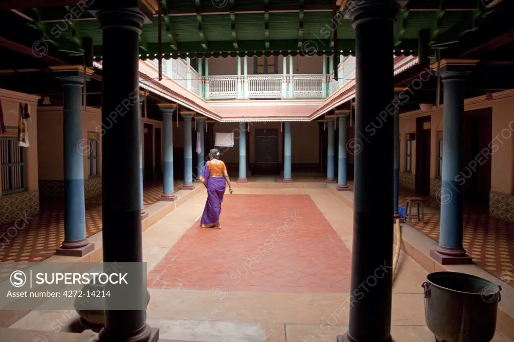 India, Chettinad. A Chettinad lady walks through an old mansion belonging to her family.