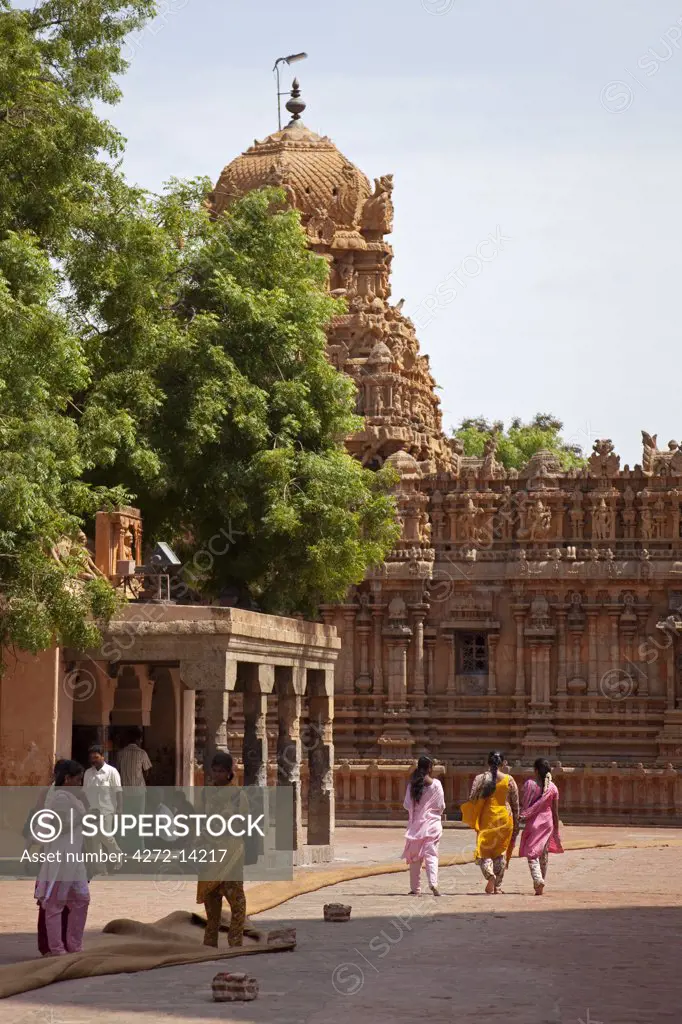 India, Thanjavur. Colourful sarees contrast with the ornate carvings of the Brihadeeswarar Temple.