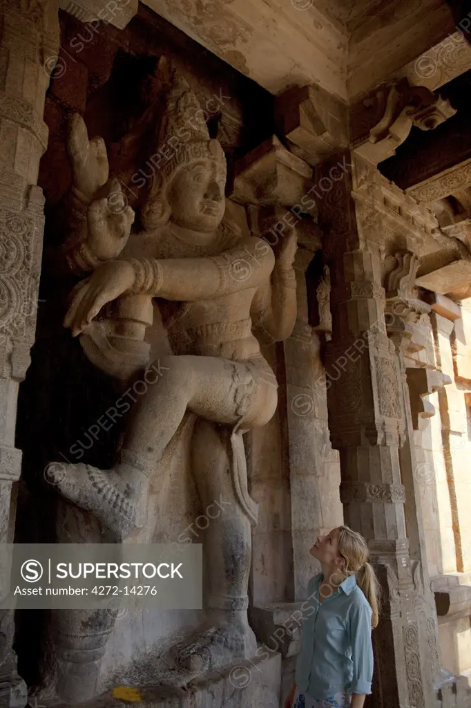 India, Thanjavur. A tourist marvels at the size of a carving of a deity at the Brihadeeswarar Temple. MR.