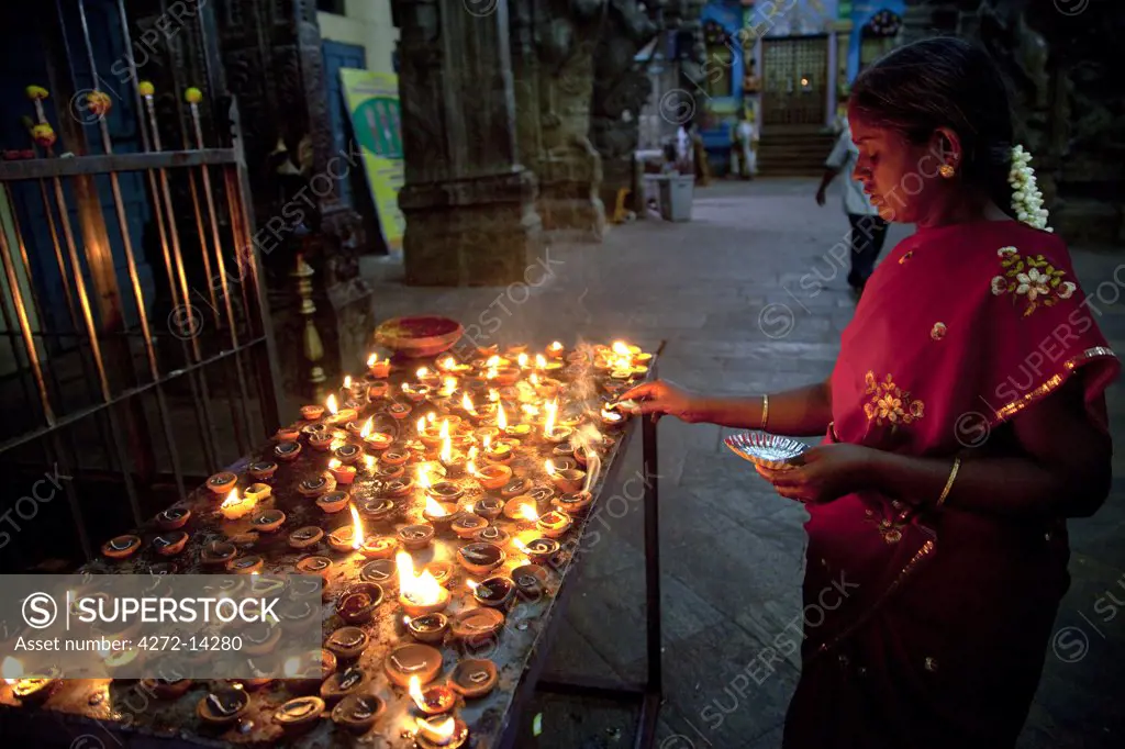 India, Madurai. A woman makes an offering at the Meenakshi Sundereshwara Temple.