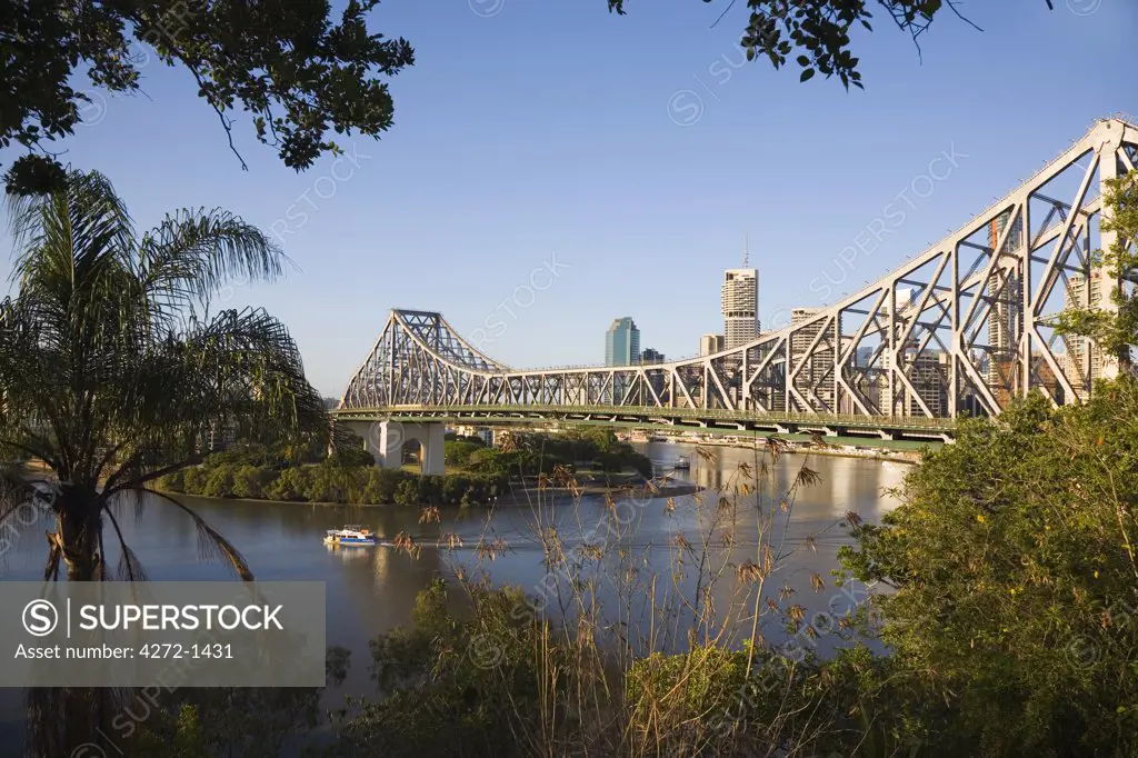 Australia, Queensland, Brisbane. Early morning light illuminates Brisbane's Story Bridge.  The iconic bridge built in the 1940's traverses the Brisbane River and links Fortitude Valley with Kangaroo Point.