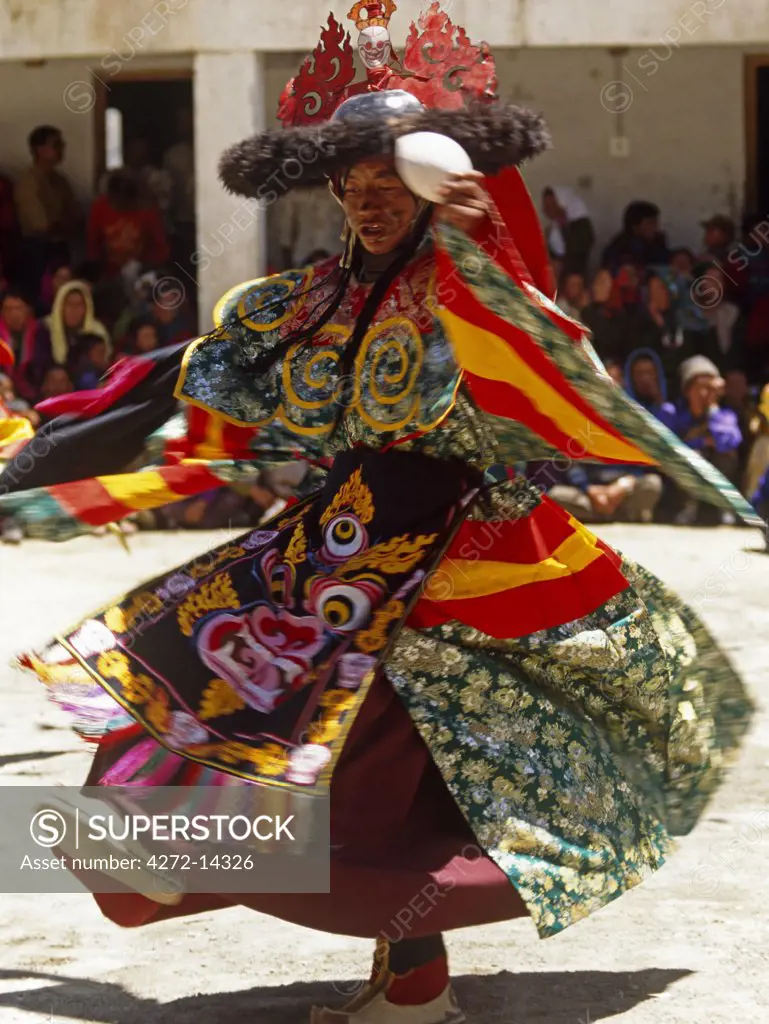 India, Himachal Pradesh, Spiti, Pin Valley, Gulling. A monk in brocade silk robes dances during a festival at Kungri Gompa, or Monastery.