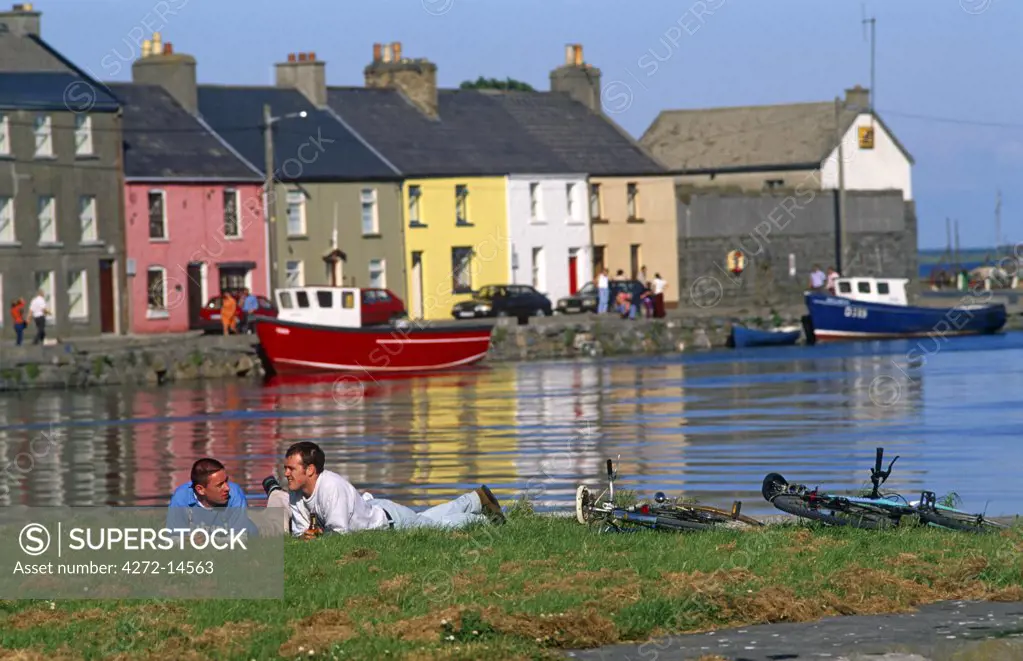 Ireland, Co. Galway. Two men relaxing, Galway Bay, Galway town.