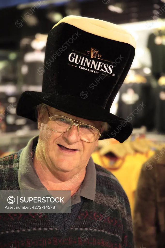 Ireland, Dublin, St James Gate, a tourist wears a Guinness hat in Dublin in the Guinness Storehouse Museum.