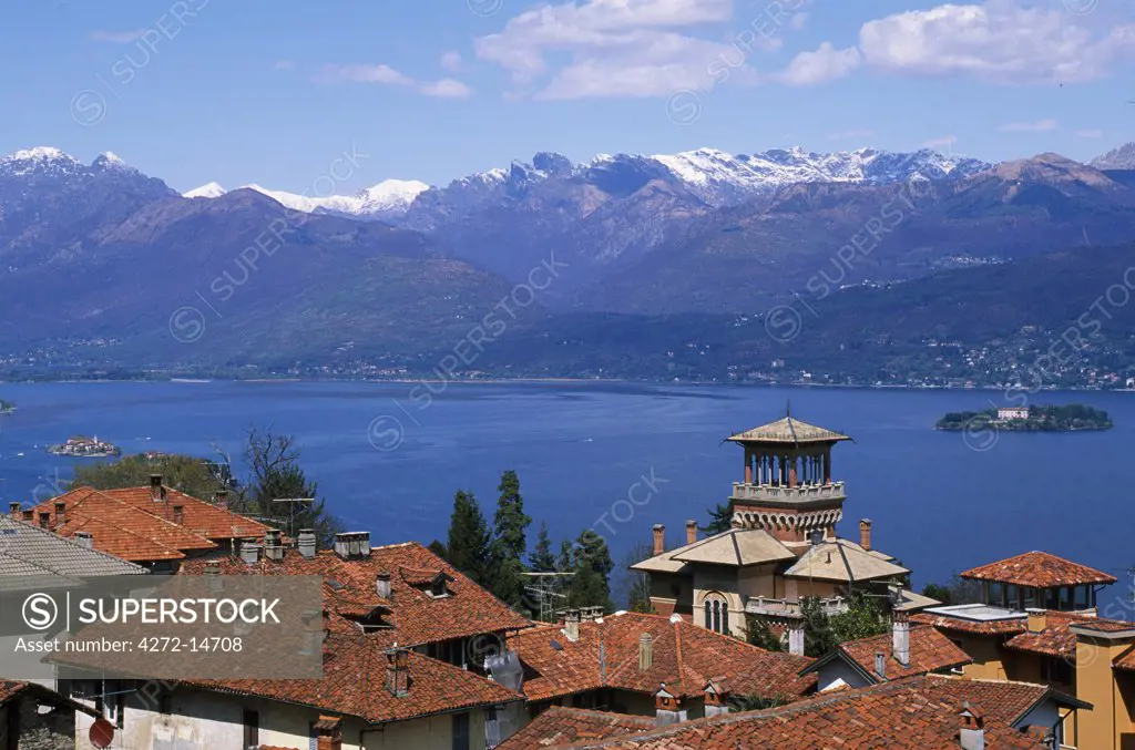 View of Lake Maggiore showing typical red roofs and snow capped mountains.