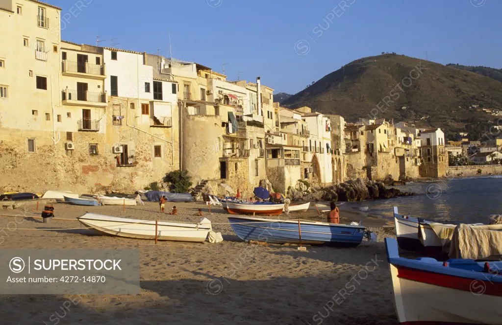 Fishing boats pulled up on the beach outside the old town at sunset