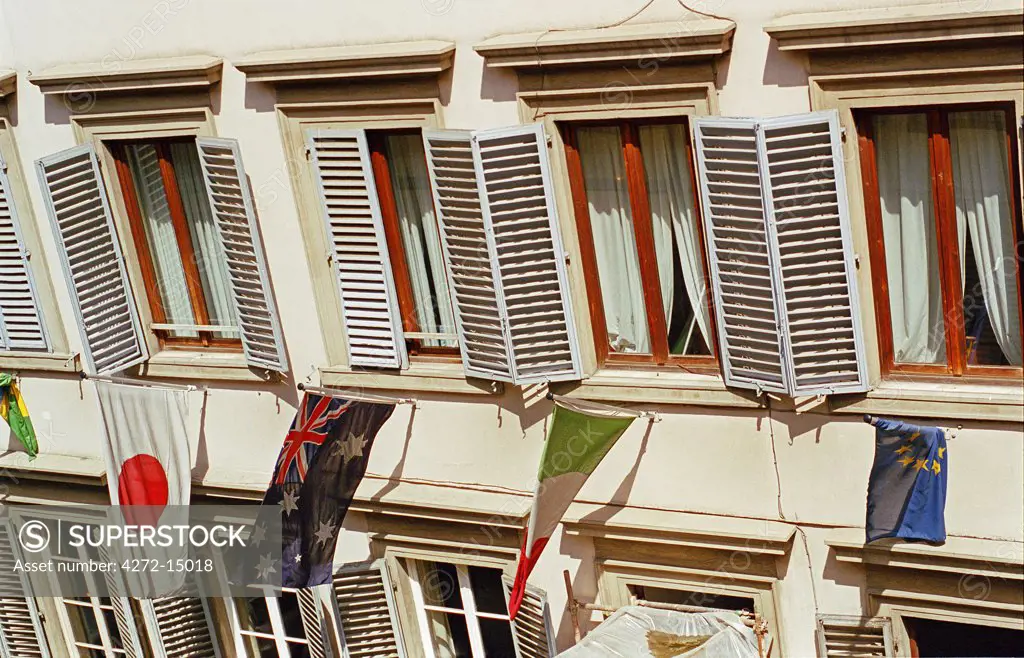 Italy, Tuscany, Florence. International flags hanging outside the shuttered windows.