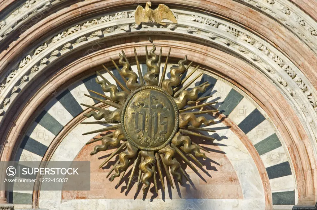Italy, Tuscany, Siena. The Sun Symbol, also the symbol of the risen Christ on the facade of the Duomo, Siena's Gothic cathedral.