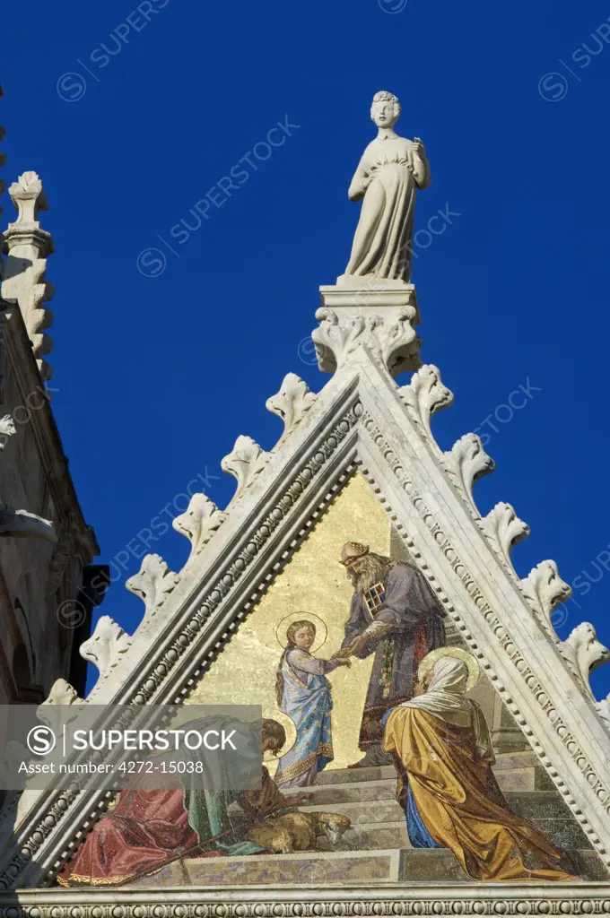 Italy, Tuscany, Siena. Detail of one of the beautifully inlaid panels and carved marble sculptures on the facade of the Duomo, Siena's Gothic cathedral.