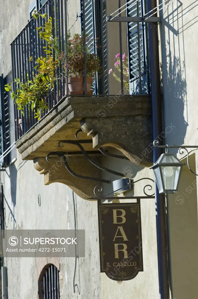 Italy, Tuscany, Montepulciano. Detail of a balcony and bar sign in Montepulciano.