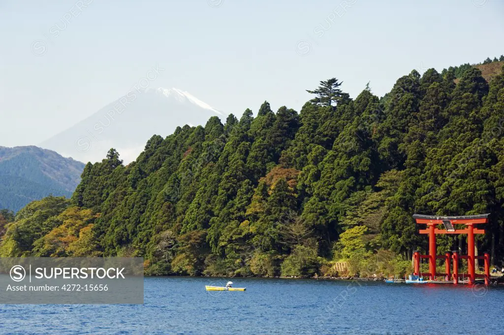 Japan, Honshu Island, Kanagawa Prefecture, Fuji Hakone National Park. Red Torii Gate on Lake Ashi with Mount Fuji (3776m) in background.