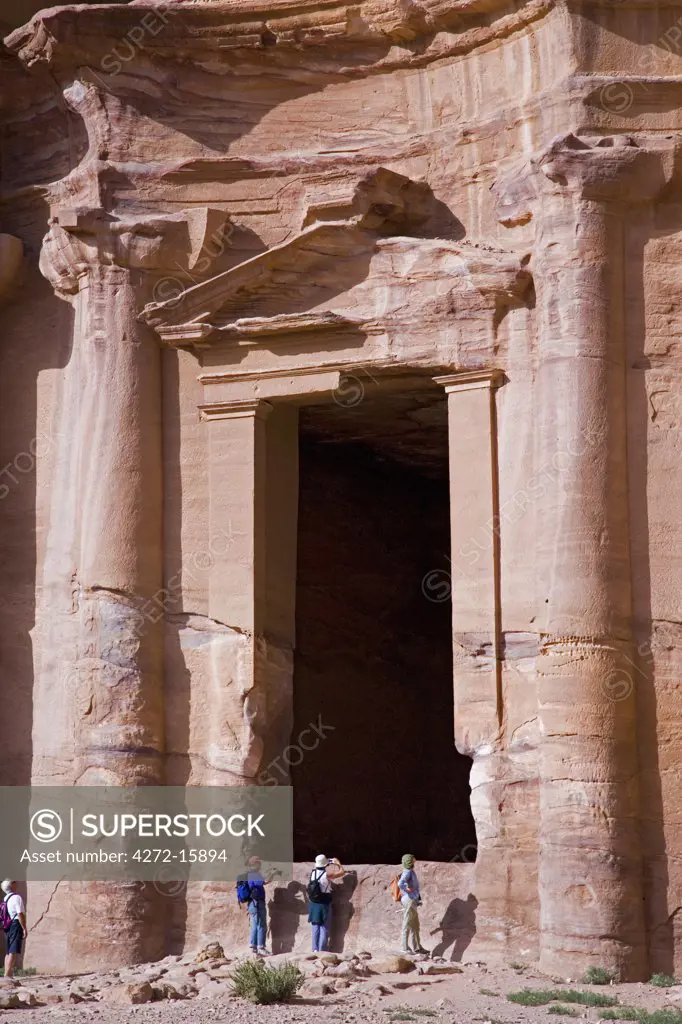 Tourists inspect the massive doorway of The Monastery, also known as El-Deir, at Petra, Jordan