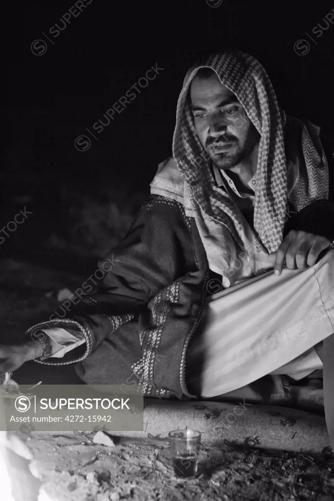 Jordan, Petra Region. A Beduin relaxing in the evening around the campfire (MR)