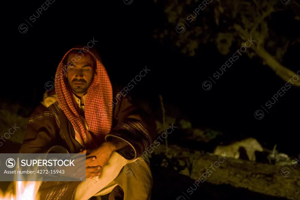 Jordan, Petra Region. A Beduin relaxing in the evening around the campfire (MR)