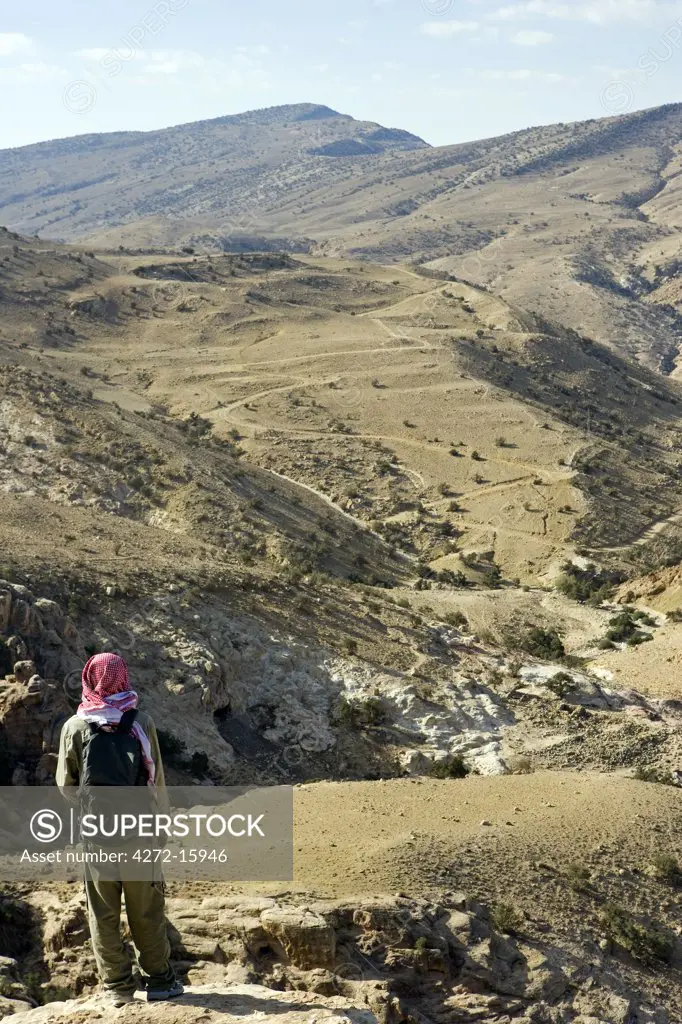 Jordan, Petra Region. Trekking the ancient trading route from the Nabeatean capital of Petra through the Shara Mountains towards the Dead Sea a local Beduin guide leads the way. (MR)