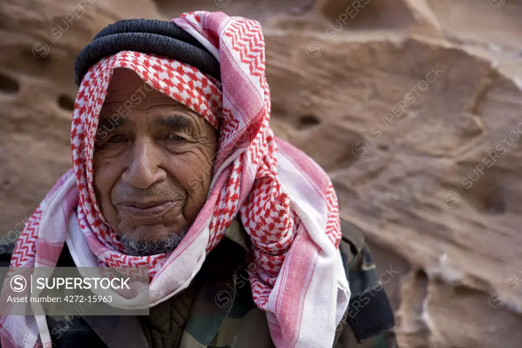 Jordan, Petra.  Portrait of local beduin caretaker resting on the steps of the 'Hidden Way', the secret entrance to the rear of the ancient Nabataean tradiing capital of Petra.