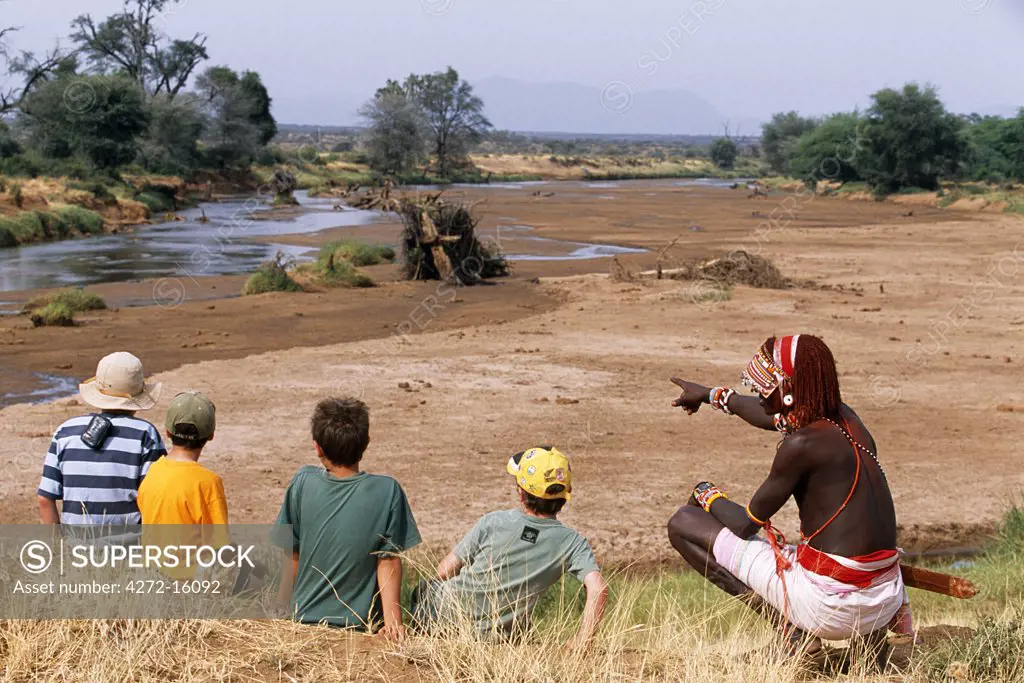 A Samburu warrior talks to children about the bush on a Cheli & Peacock family safari.