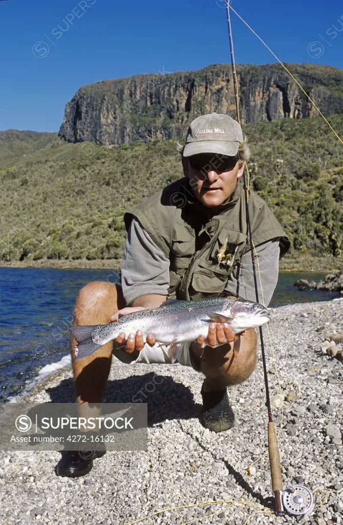 Kenya; Mount Kenya.   Erik van Vliet, Vice Chairman of Kenya Flyfishers Club with a nice rainbow trout on Lake Alice.