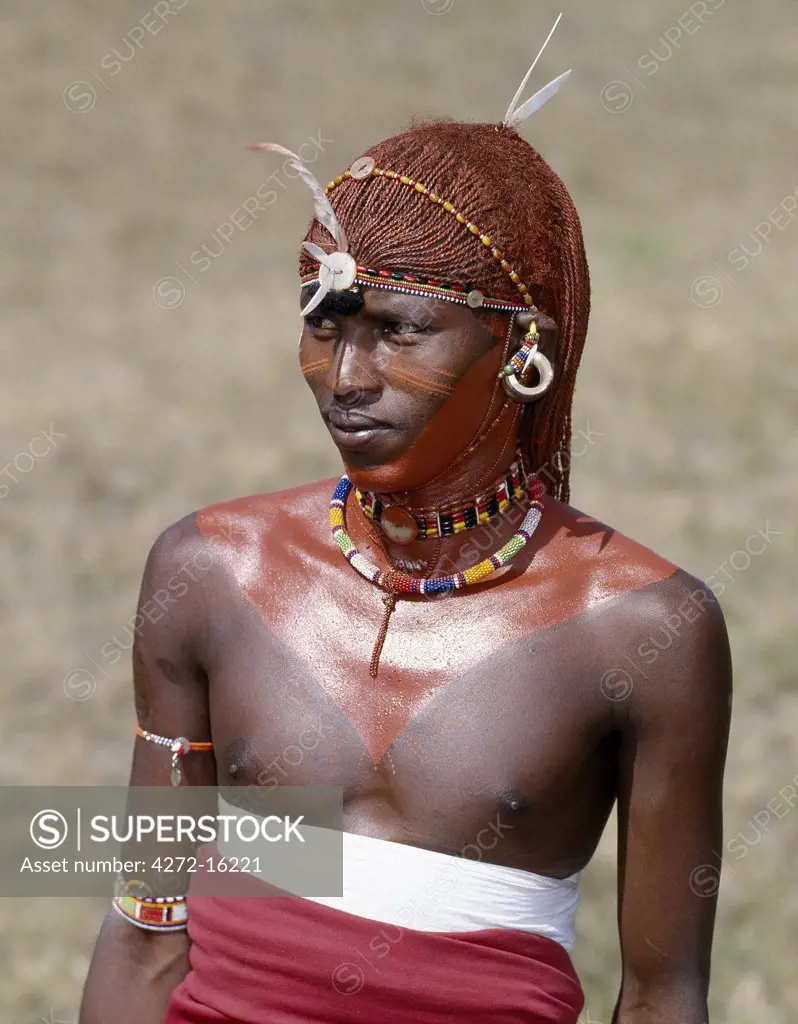 A Samburu warrior resplendent with his long braids of Ochred hair.  His round ear ornaments are made of ivory.  Samburu warriors are vain and proud, taking great trouble over their appearance. They use ochre extensively; it is a natural earth containing ferric oxide which is mixed with animal fat to the consistency of greasepaint.