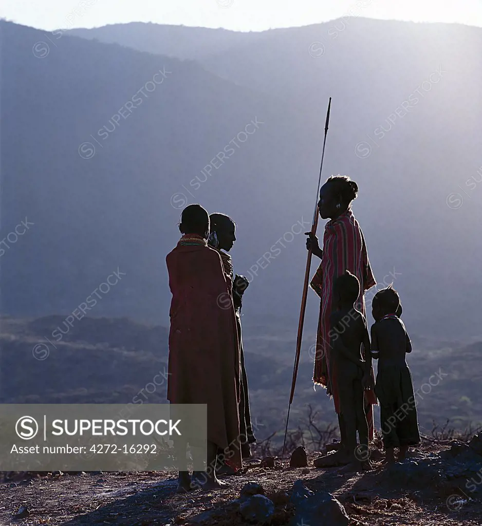 As the sun rises above the forested peaks of Mount Nyiru, members of a Turkana family chat and plan their day's activities.