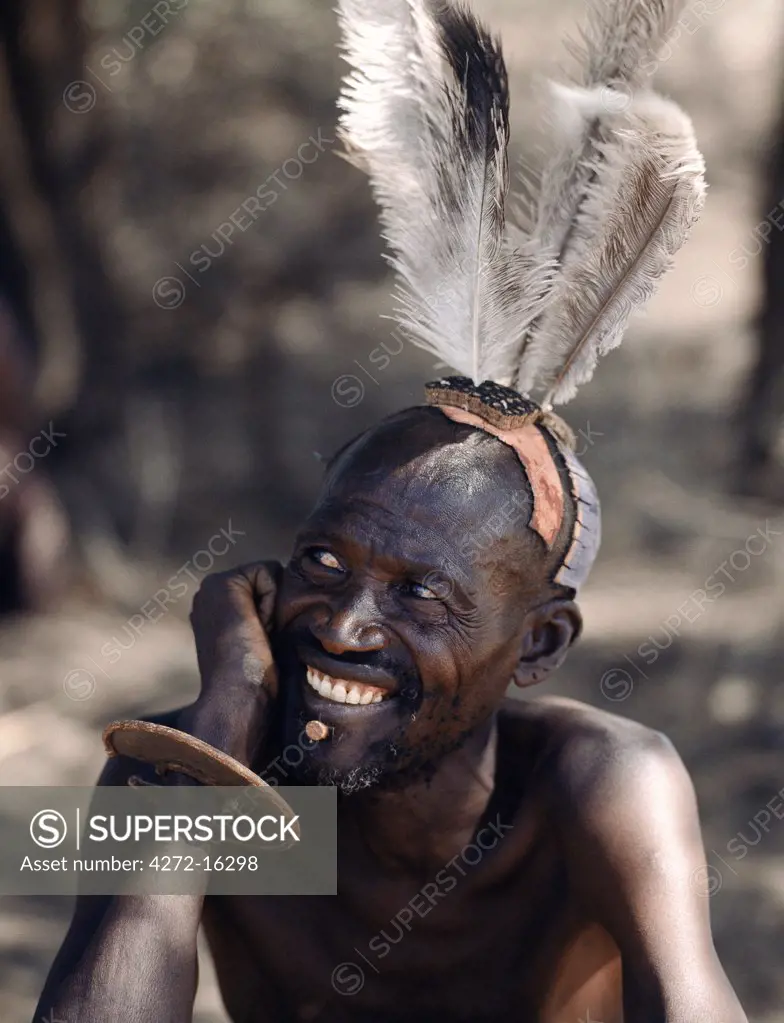 A Turkana man sports a fine array of ostrich feathers from his clay hairdo. Having discarded the discomfort of an ivory lip ornament, he has to insert a small wooden plug in the hole beneath his lower lip to prevent dribbling.