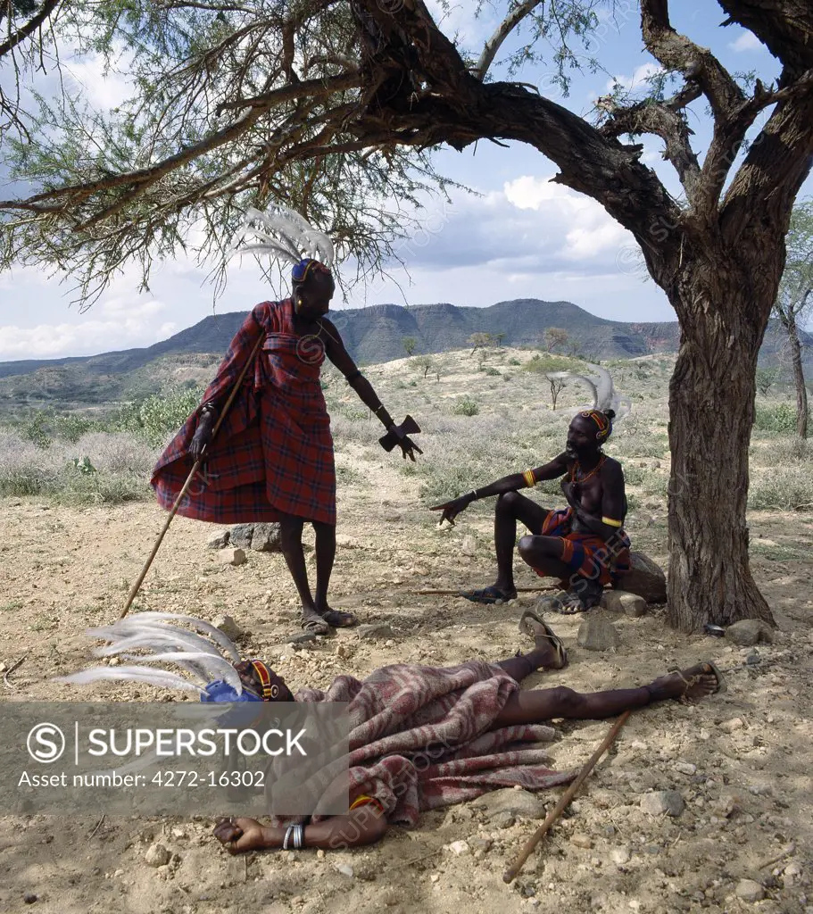 A short distance from a homestead and invariably to the east (the direction from which come life, light, and the sun) Turkana elders rest during the heat of the day in the shade of a tree.  Every man carries a small wooden stool, which doubles up as a pillow at night.