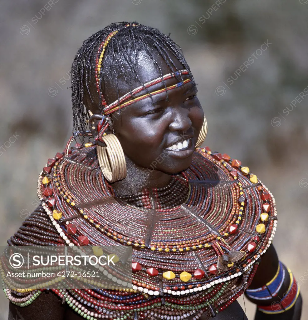 A young married woman of the Pokot tribe.  Her married status is denoted by her large brass earrings and broad beaded collars and necklaces that are smeared with animal fat to glisten in the sun.