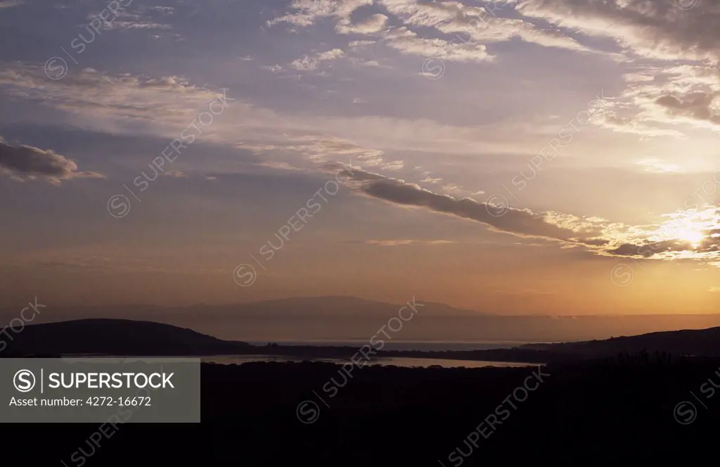 Sunrise over Lake Naivasha with the Aberdare Mountains rising to a height of 13,000 feet in the distance.   Lake Naivasha is the highest lake of Africa's Great Rift Valley and has the reputation as an ornithologist's paradise.