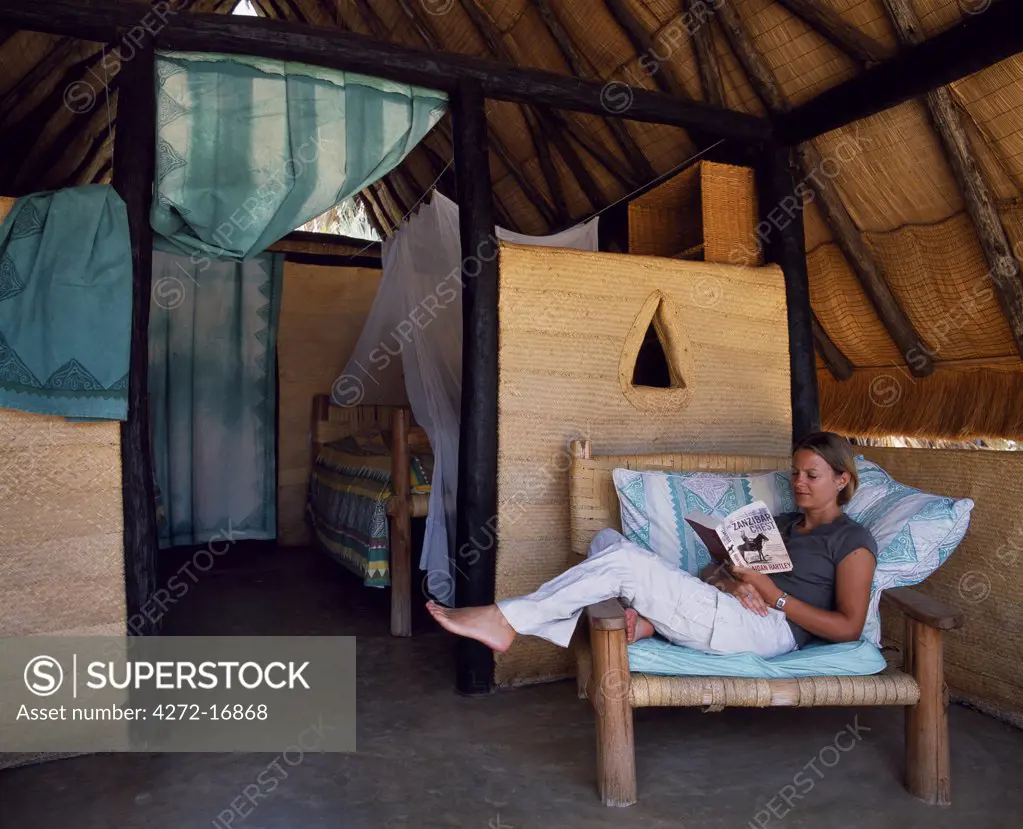 A guest relaxes in one of the thatched accommodation huts of Kalacha Lodge, a self-catering tourist lodge operated by the local Gabbra community at Kalacha on the edge of the Chalbi Desert.