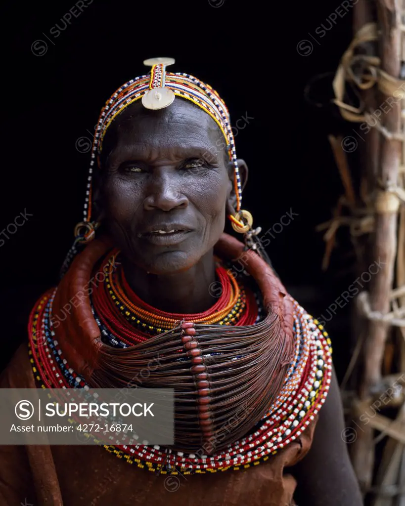 A Turkana woman, typically wearing many layers of bead necklaces and a series of hooped earrings with an pair of leaf-shaped earrrings at the front.