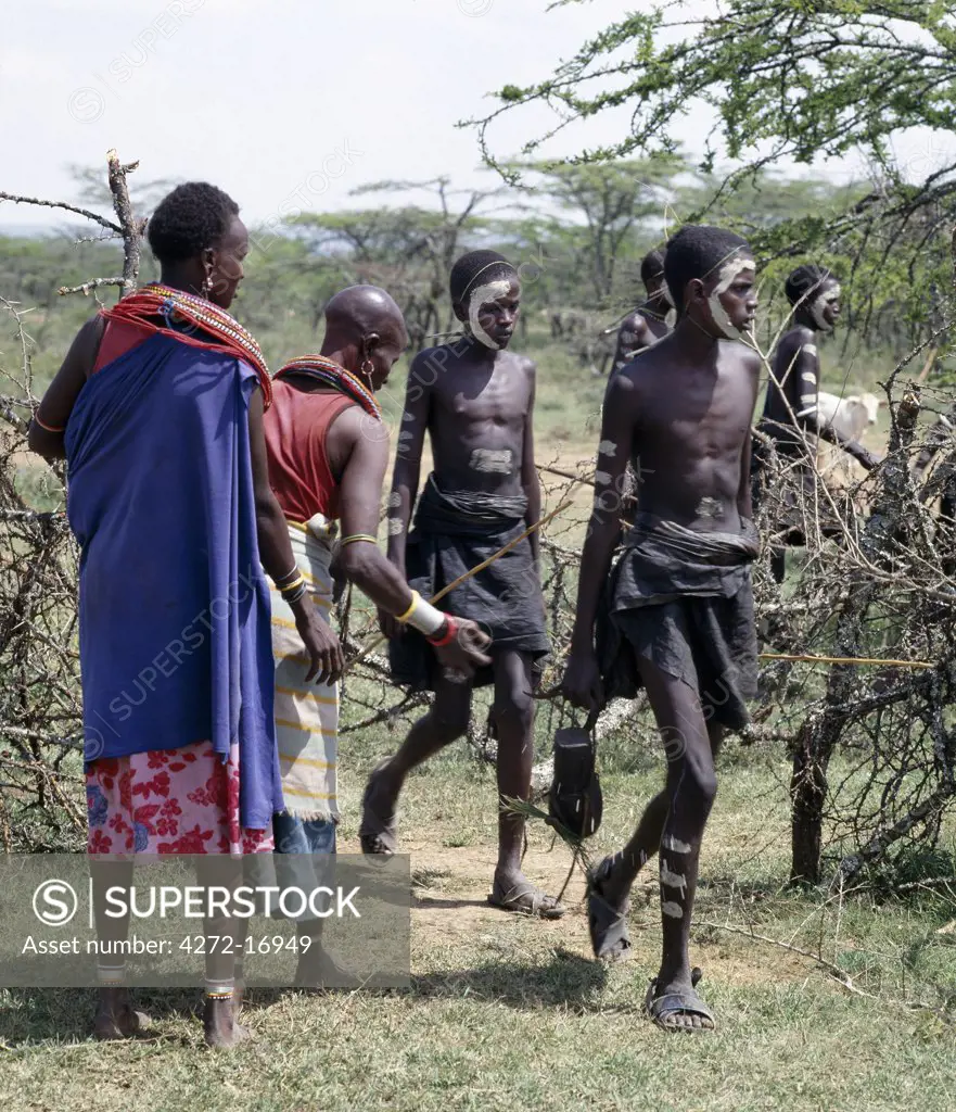The day before their circumcision, Samburu boys are blessed by their mothers by having milk flicked on their feet as they return to their lorora from a water source that never dries up.