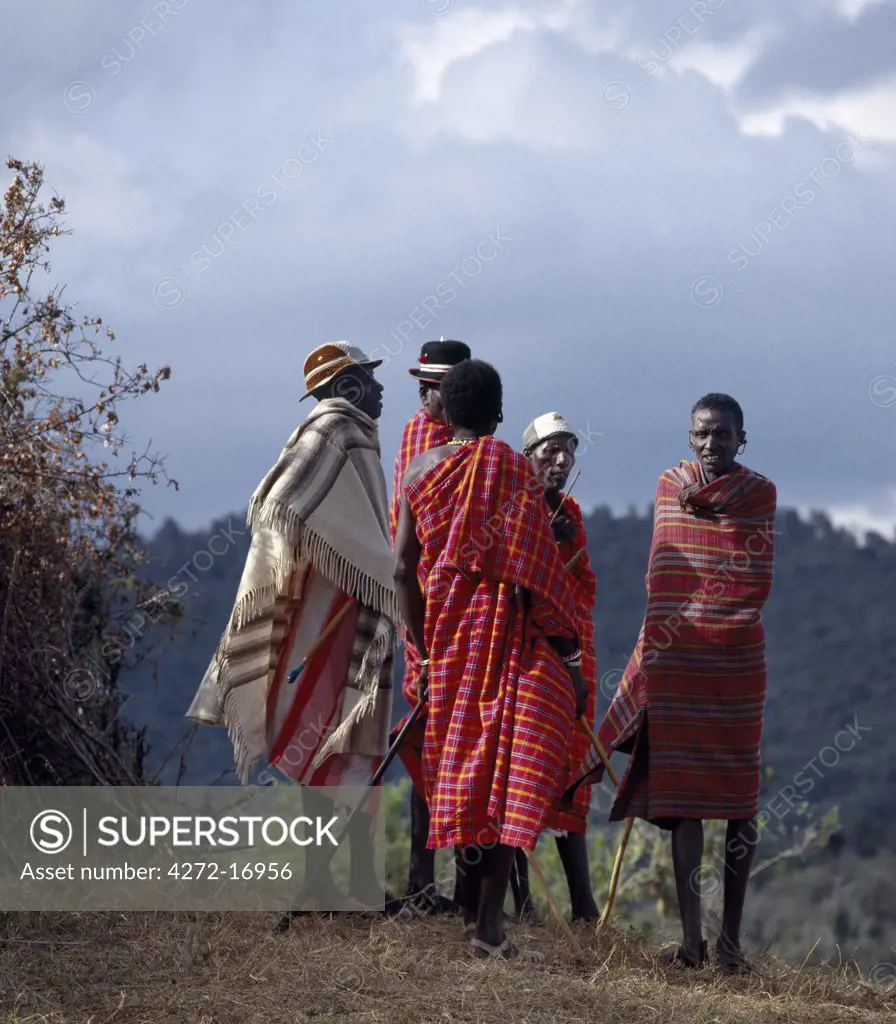 Blanket-clad Samburu elders converse outside a lorara, a purpose-built circumcision encampment for boys. The elders meet frequently in the days leading up to their sons' circumcision to discuss the arrangements.