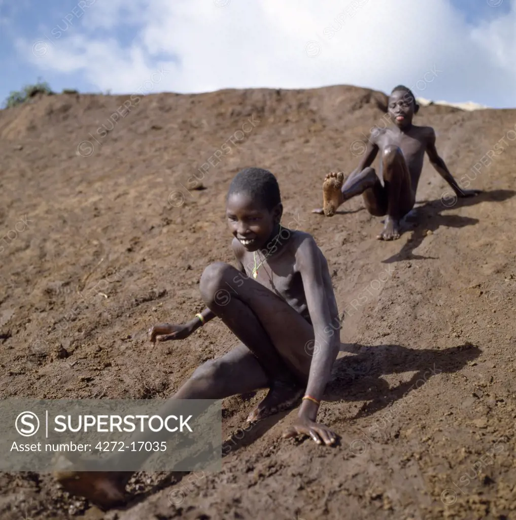 Young Samburu boys enjoy themselves on a mudslide.