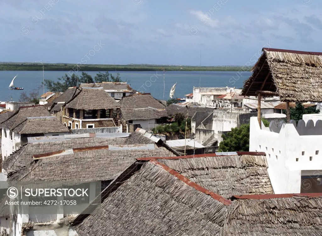 A view over makuti thatched roofs to the estuary that divides Lamu Island from uninhabited Manda Island, which has no permanent source of sweet groundwater. Mashuas, the small wooden sailing boats of the East African Coast carry passengers and cargo from nearby Kenya mainland to the island.