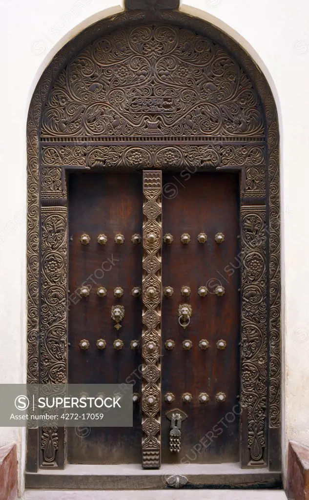 A fine example of a carved wooden door in Lamu town.   Wood carving is the most important craft in Lamu and sustains the greatest number of skilled craftsmen. It will take experienced craftsmen eight man-months to make such a beautiful door and frame.