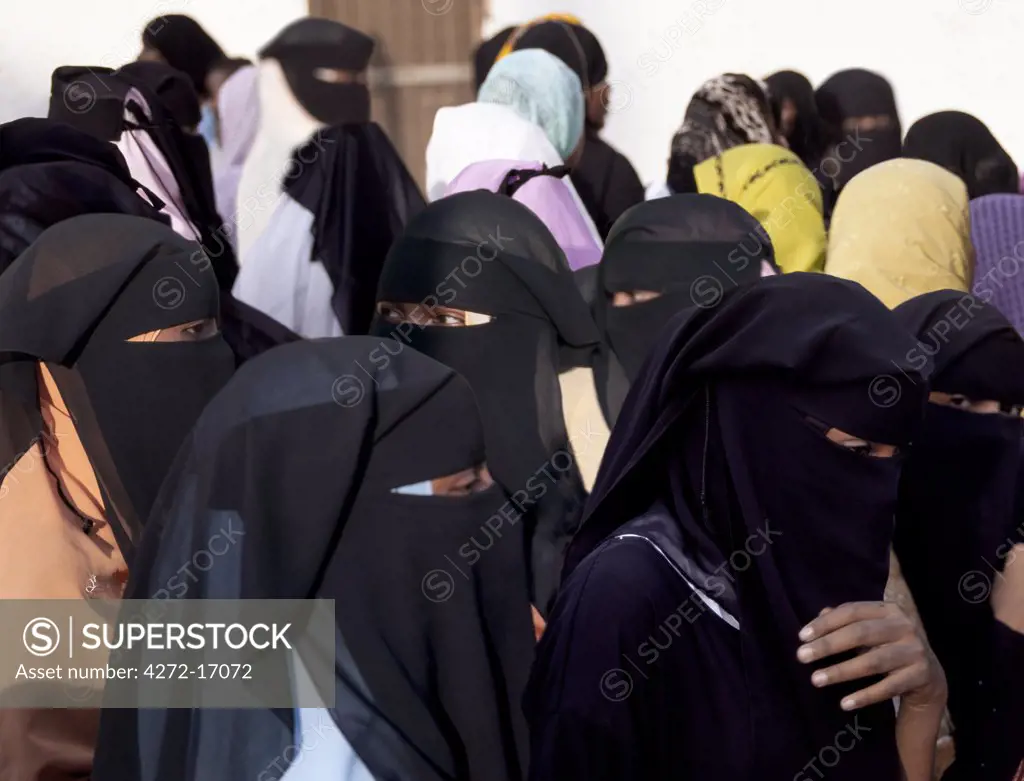 A group of Lamu women wearing traditional Islamic dress and face veils gather for a festive occasion. Situated 150 miles north northeast of Mombasa, Lamu town dates from the 15th century AD.