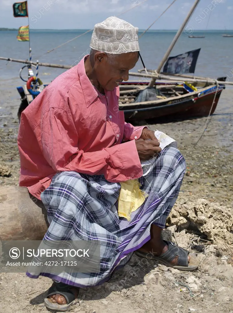 A man embroiders a Swahili hat along the waterfront at Kisingitini, a natural harbour on Pate Island. It takes hours of patience and great skill to finish a really fine hat, which will be prized by Muslims throughout the Lamu Archipelago and elsewhere.