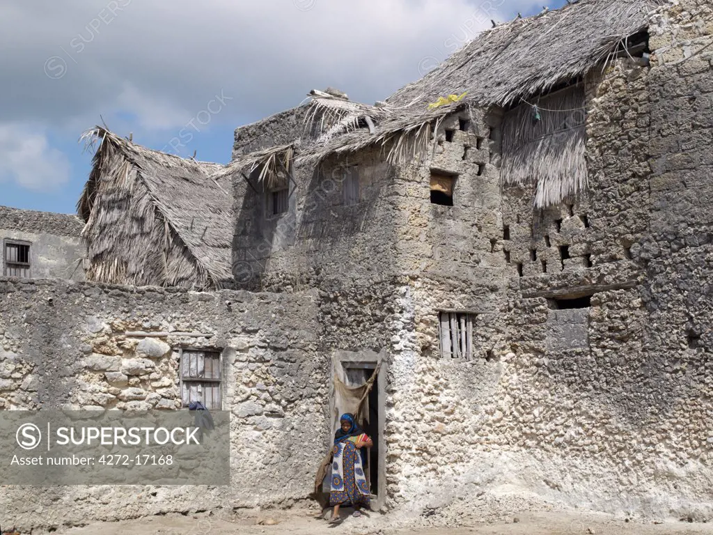 A Swahili woman leaves her large double storied building in Pate Village. All the buildings in Pate are constructed of coral rag with makuti roofs, which are a type of thatch made from coconut palm fronds. Pate was established by Arabs from Arabia in the 13th century, or possibly earlier.