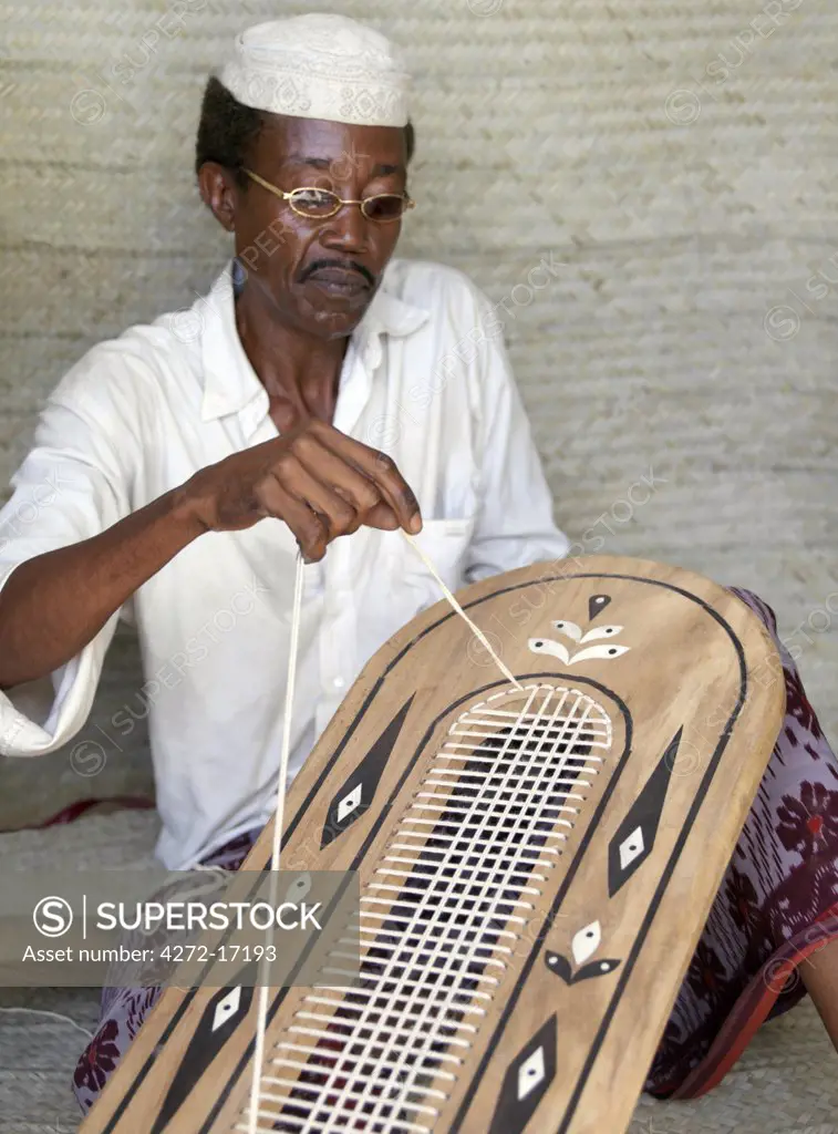 A Lamu man strings the back of a traditional Lamu style chair embellished with marquetry. Situated 150 miles north-northeast of Mombasa, Lamu town dates from the 15th century AD.