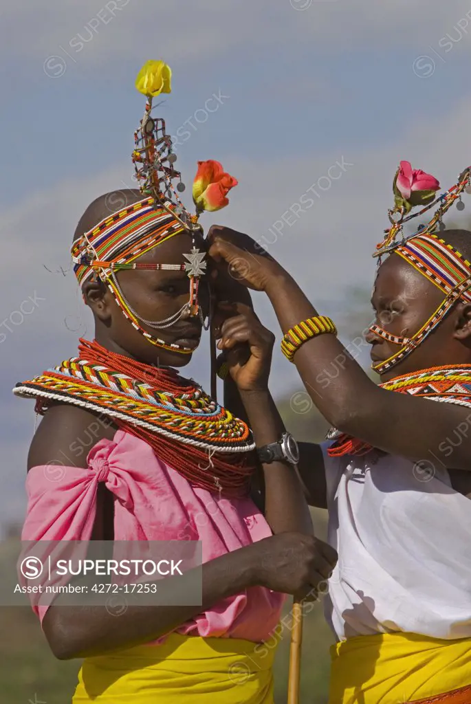 Two young Samburu girls help each other preparing for a celebration, Wamba District, Kenya