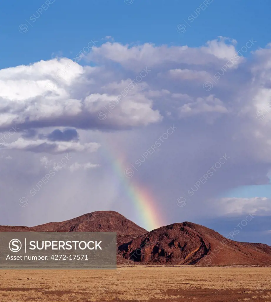 Africa, Kenya, Sirima, Turkana District. A rare shower of rain with a rainbow in the barren, lava-strewn country on southeast side of Lake Turkana.