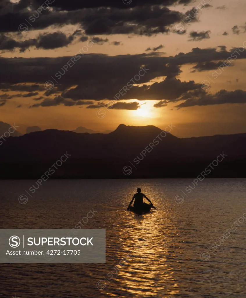 Kenya, Baringo, Lake Baringo. In the setting sun, an Il Chamus boatman paddles his small raft across Lake Baringo. The rafts are made from the light wood of the ambatch tree that grows in swampy ground around the lake.