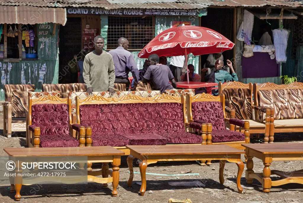 Kenya, Kisumu District. A furniture maker and upholsterer displays his various styles of sofa sets and tables on the roadside near Kisumu.