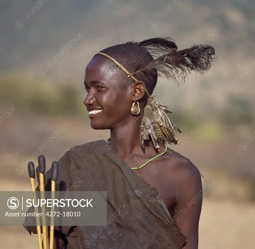 A Samburu initiate in traditional costume with the skinned birds he has shot with blunt arrows hanging from his headband.