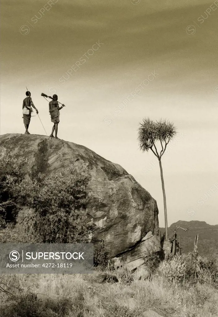 Kenya, Laikipia. Two Laikipiak Maasai men look out over the wild country at Sabuk.