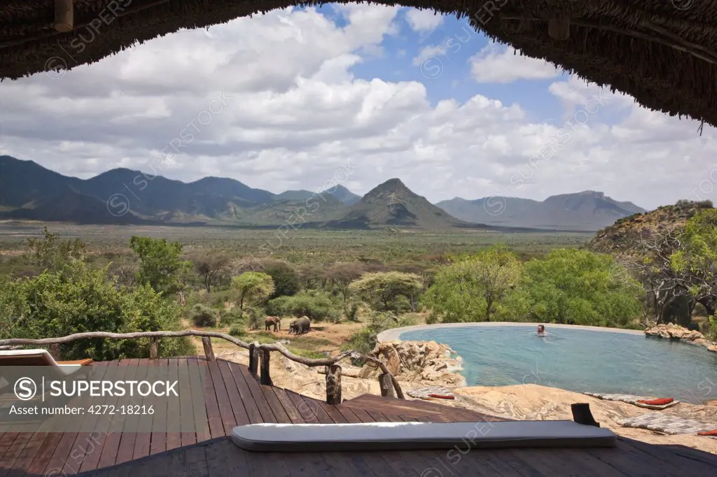 Kenya, A guest enjoying the natural rock swimming pool of Sarara Camp, an ecolodge situated near the Mathews Mountains