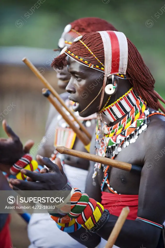Kenya, Laikipia, Ol Malo.  Samburu warriors sing, clap and dance in their traditional dress at a manyatta